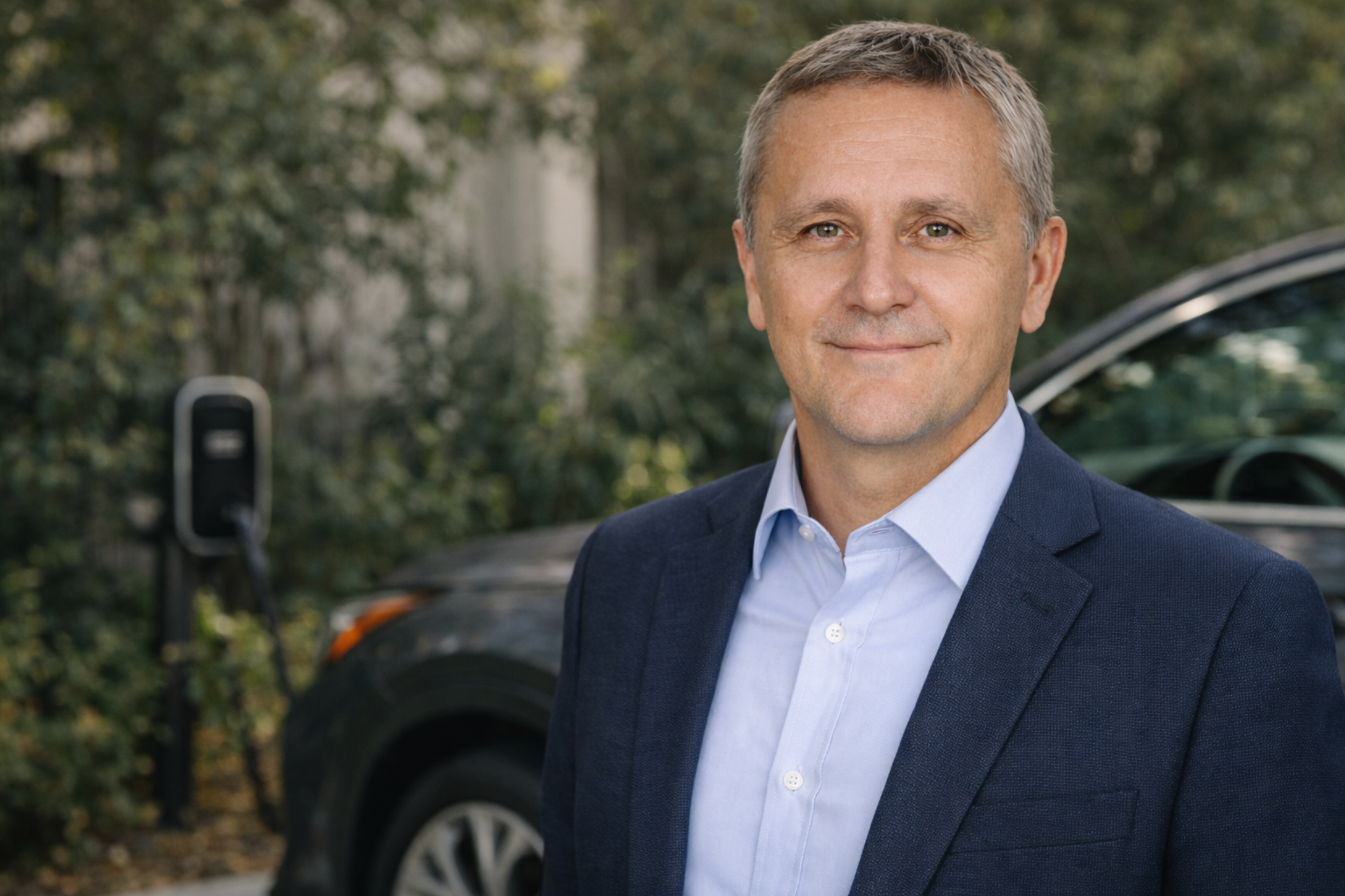 Max Solo portrait near a vehicle and EV charger